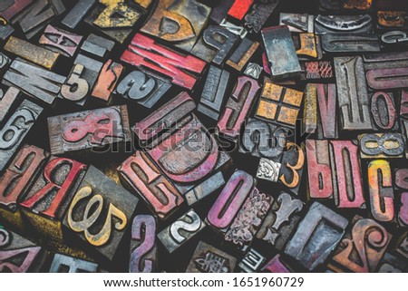 A coloured, textured background of antique wooden type-setting letter blocks with various fonts, upper- and lowercase, antique letters, ...