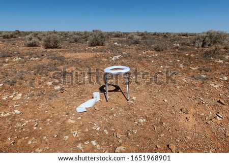 Portable toilet with toilet paper roll in the desert. Australia.