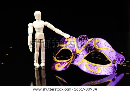wood dummy with carnival mask in black background