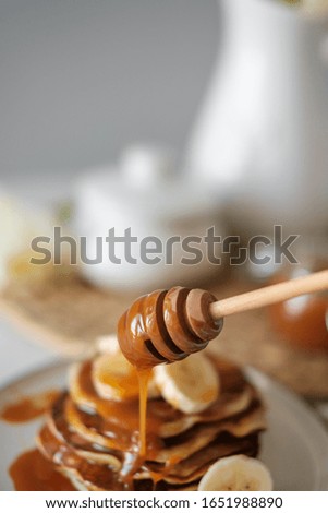 delicious American pancakes with bananas and honey on the plate for a breakfast. selective focus. Scandinavian style kitchen. Beautiful breakfast