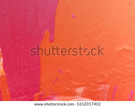 emulsion paint, red, pink, orange and white are mixed in the paint bucket. The image taken from the top of the paint bucket