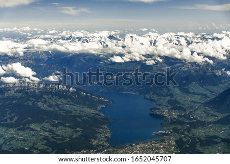 Landscape aerial view of Zurich city, Switzerland, with colorful houses, forest with trees, lake Zurich, hills, and fields