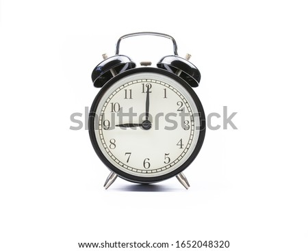 Black vintage alarm clock on a white background shows nine o'clock Royalty-Free Stock Photo #1652048320