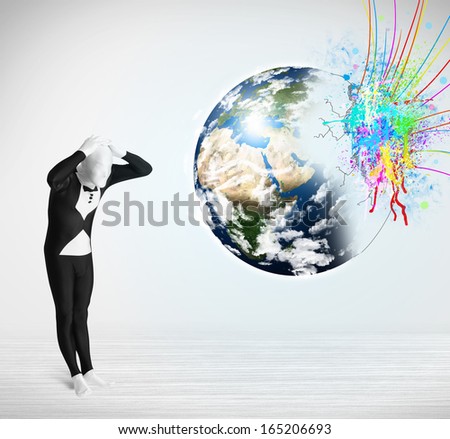 Funny man in body suit looking at colorful splatter 3d earth