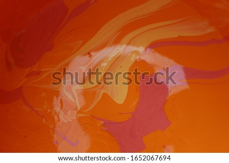 white, red, pink, and orange emulsion colors are mixed in a paint bucket. Images taken from the top of the paint bucket. Color mixing by hand