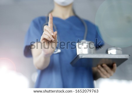 Close up of doctor pointing up finger