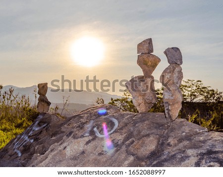photography of stacked stones at sunset