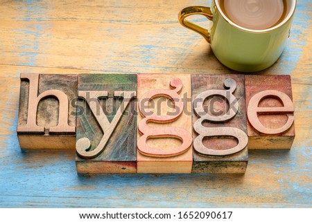 hygge word in vintage letterpress wood type blocks against grunge woodwith a cup of coffee, Danish comfortable and cozy lifestyle concept