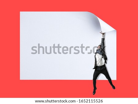 Imagine who's covering white sheet to get digital file icon. Office style young man catching the edge of huge paper sheet. Digital world, funny imagination of the way the icon's appearing.