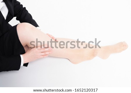Business woman massaging foot taken in studio