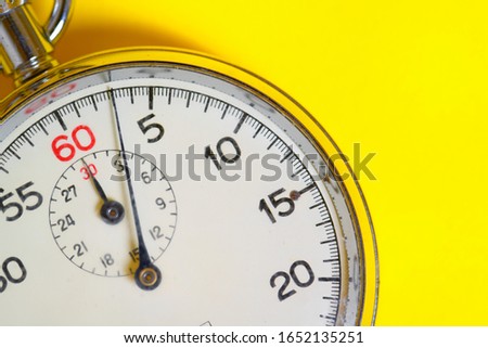 Classic stopwatch on a yellow background