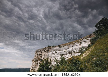 Beautiful stone cliff and big lake. Old stone caves, green hill and river landscape. Bakota lake and Dnister river in Ukraine.Travelling and exploring national park. Summer vacation