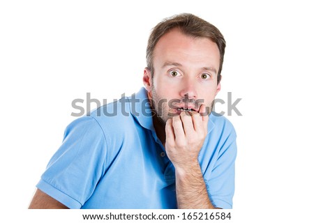 Closeup portrait of a young handsome man in blue shirt hands hand in mouth very anxious and tense in anticipation of something, isolated on white background. Negative human emotion facial expression Royalty-Free Stock Photo #165216584