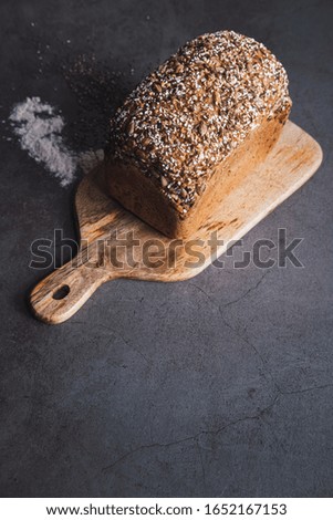 Buckwheat bread with multi seeds on wooden table. Vertical picture. Copy space.