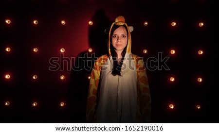 A woman in bright children's pajamas in the form of a kangaroo. emotional portrait of a student. costumed presentation of children's animator.