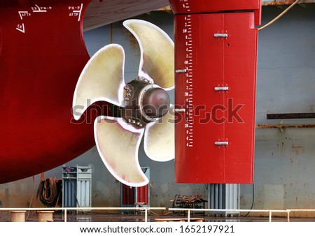 Propeller closeup of container ship in floating dry dock of shipyard Royalty-Free Stock Photo #1652197921