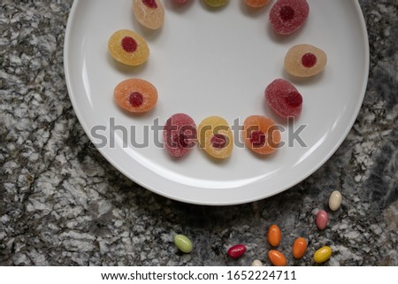 Easter candies in a raw in a white plate on a gray granite table. Concept, High angle view, space for text.