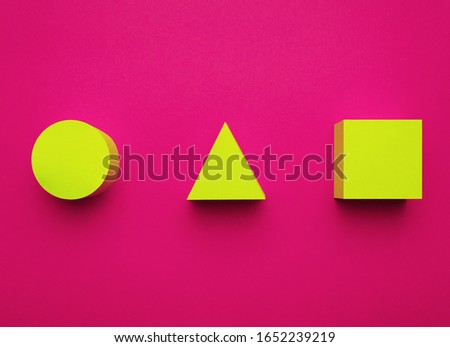 Yellow circle, triangle and square made of paper on a bright purple background. Creative futuristic concept. 3D effect.