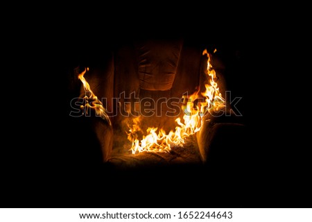 burning armchair close-up on a black background