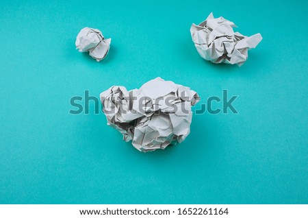 studio photography of a rumpled paper ball. Paper ball on the blue backround