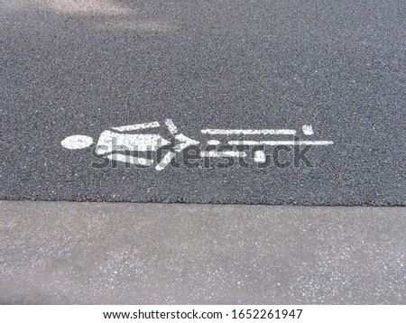 Traffic road sign for bicycle lane on road next to pavement in Japan. Man riding bike sign for cycle lane