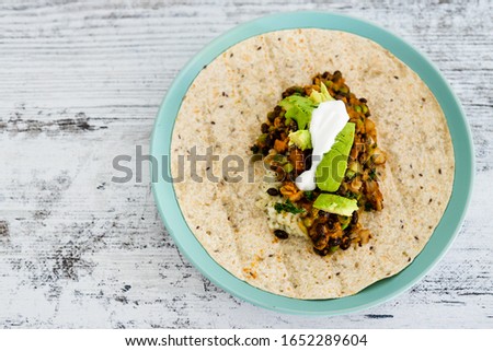 healthy blant-based recipes concept, beans rice and avocado open wrap with vegan aioli