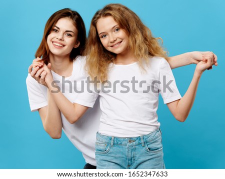 Woman and little girl on a blue background fun family mom and daughter