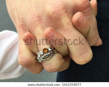 Birthstone Mother's Ring Featuring Emerald and Topaz on Adult's Hand, Holding Hands with Young Daughter Royalty-Free Stock Photo #1652354077