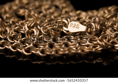 golden necklace of test 925 on a black background. close up Royalty-Free Stock Photo #1652410357