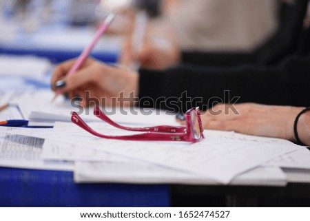 Hands of a woman writing on a piece of paper.