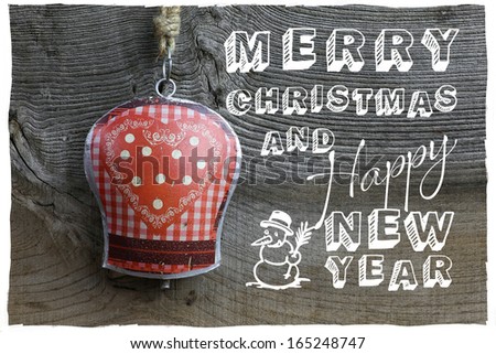 Merry Christmas message, handmade decoration gingham heart pattern on tin bell over rustic Elm wood background - retro style design
