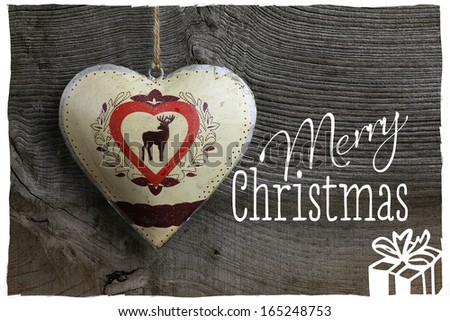 Merry Christmas message, handmade decoration deer in tin heart over rustic Elm wood background - retro style design