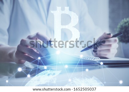 Cryptocurrency hologram, bitcoin, ico theme over hands taking notes background. Concept of blockchain. Multi exposure