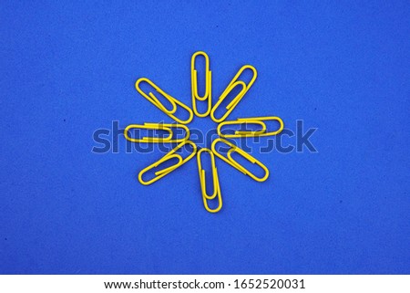     colored paper clips on a blue background                           