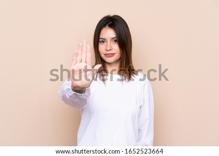Young woman over isolated background making stop gesture with her hand