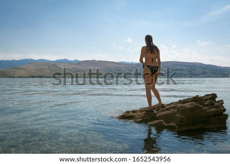 A girl on a rocky seashore. Made on the Adriatic Sea, Pag in Croatia.