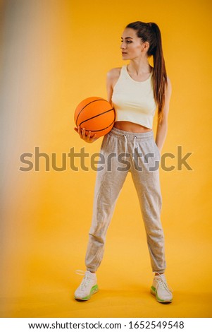 Young woman basketball player isolated at studio