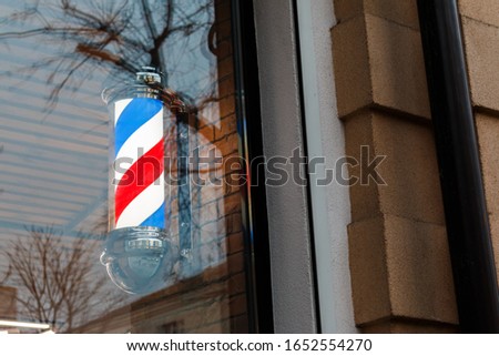 Barber shop pole background. masculinity, masculine beauty, personal care concept. A classic barber pole set behind the window glass
