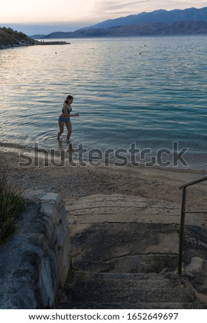 Girl running on the beach at dusk. Made on the Adriatic Sea, Pag in Croatia.