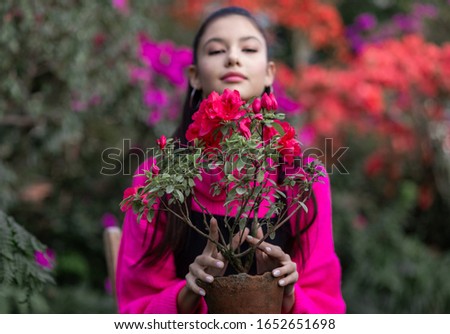 a young gardener girl is happily taking pictures with her flowers