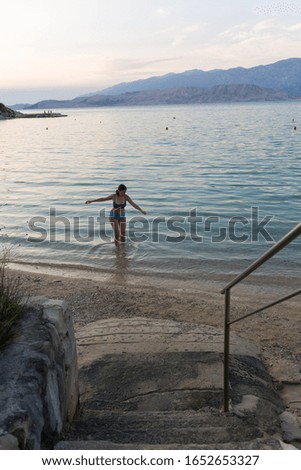 The girl enters the sea. Made on the Adriatic Sea, Pag in Croatia.