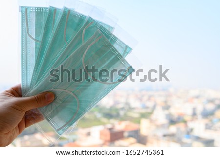 man holding some brand new disposable medical face masks