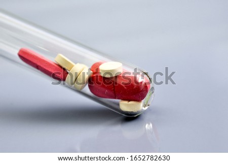 red and white pills in a dusty test tube.