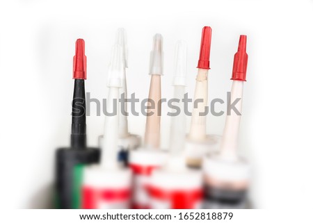 Nozzles of a used silicone to caulk on a white Royalty-Free Stock Photo #1652818879