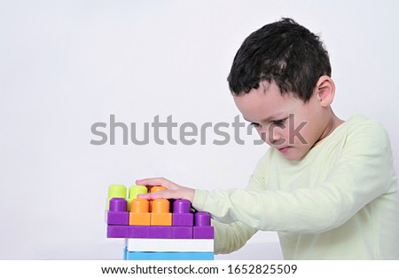 child with toy building blocks testing his creativity by building a house stock photo