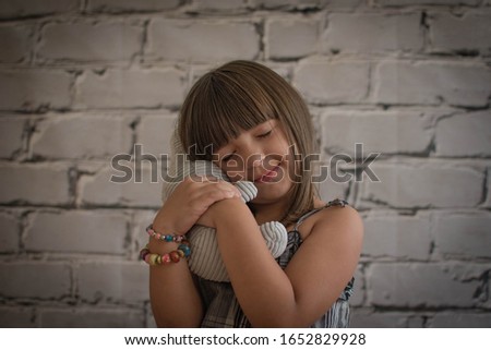 
Small girl plays with stuffed animal