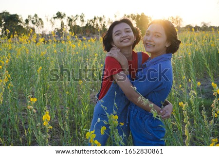 Two happy Asian young girl at flower garden on summer with nice sky.