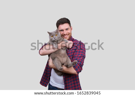 Man Holding Cat in Hands. British Gray Cat. Man with Cat Smiling. Isolated Royalty-Free Stock Photo #1652839045