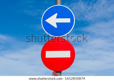 Red no entry road sign and blue direction arrow traffic sign