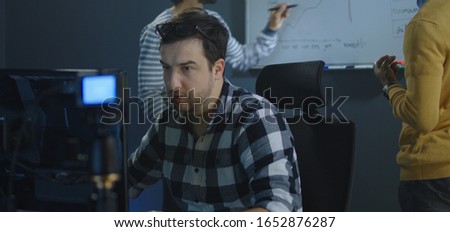 Medium shot of a man recording a video for a vlog in an office